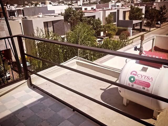Barandal de terraza con vista abierta a la ciudad en una residencia de León